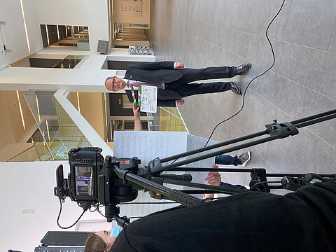 Blick durch eine Filmkamera auf den Rektor während der Videoarbeiten zur Langen Nacht der Wissenschaften im Nieper-Bau-Foyer