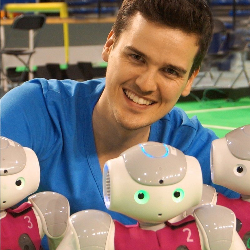 Portraitfoto mit drei kleinen humanoiden Robotern davor