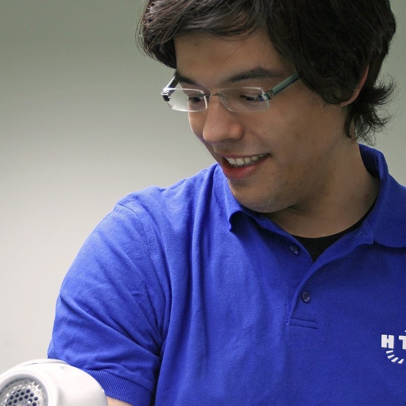 Portraitfoto mit einem kleinen humanoiden Roboter auf dem Arm
