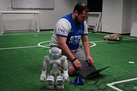 Florian Mewes mit Nao auf dem Trainingsplatz. (Foto: F. Platz/HTWK Leipzig) Florian Mewes mit Nao auf dem Trainingsplatz. (Foto: F. Platz/HTWK Leipzig)