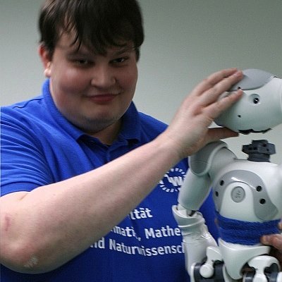 Portraitfoto mit einem kleinen humanoiden Roboter in der Hand